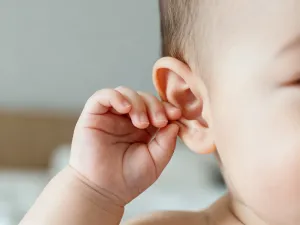 Kolorowa mata edukacyjna z drewnianymi klockami i pluszową zabawką w przytulnym, słonecznym pokoju dziecięcym.