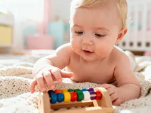 Mama przytula noworodka w przytulnym pokoju dziecięcym, budując bliskość i poczucie bezpieczeństwa.