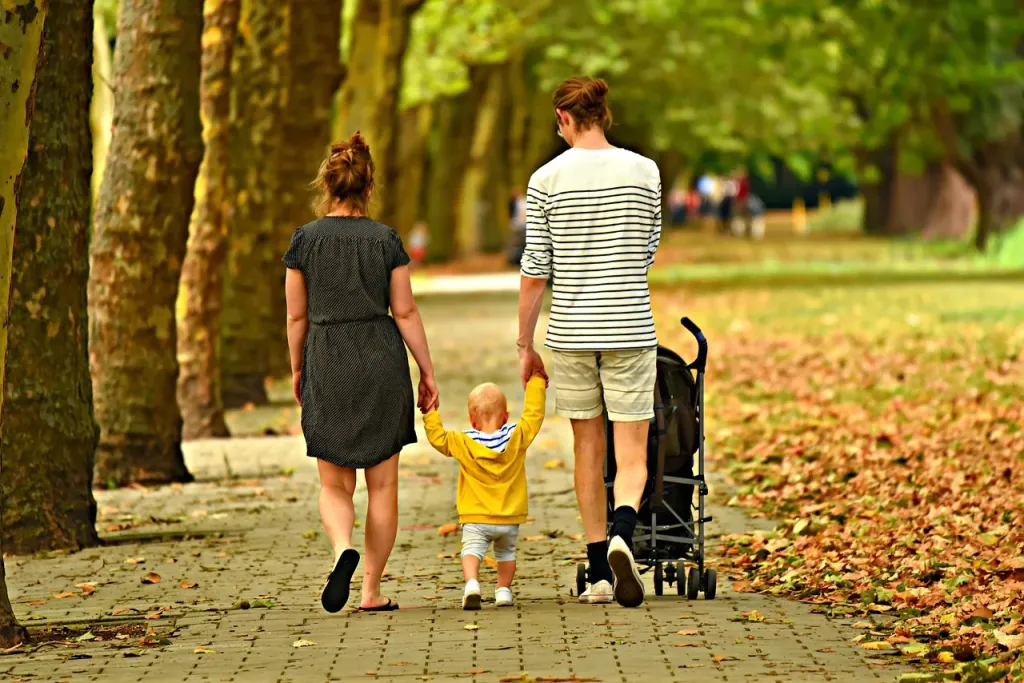 Matka czule obejmująca dziecko podczas spaceru na świeżym powietrzu, symbolizująca miłość i więź rodzinną.